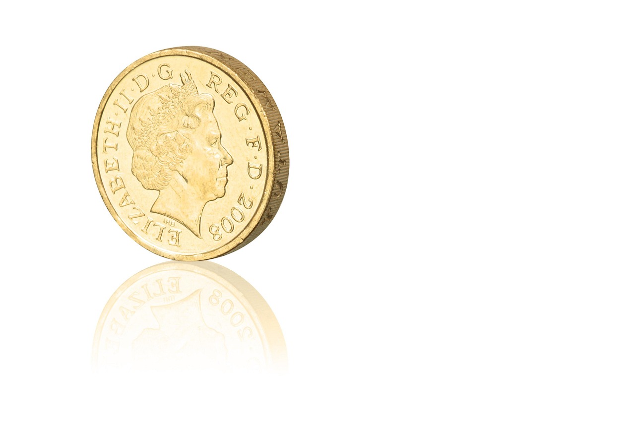 Sterlina d'oro su un tavolo, simbolo di investimento e collezionismo, con grafico del valore in background.