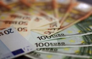 Pensionato riceve il bonus extra di 150 euro per redditi bassi, con documenti e sorriso.