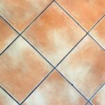 Pulizia delle fughe del pavimento con spazzola e detergente efficace.