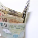 Due persone che discutono su un conto corrente cointestato, con documenti e un computer.