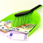 Donna che pulisce una stanza con prodotti eco-friendly e sorridente, pianificando il budget per le pulizie di primavera.