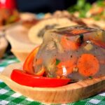 Piatto tradizionale preparato con ingredienti freschi a km zero, servito su un tavolo rustico.