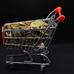 Immagine di un negozio fisico con cartelli promozionali sul cashback e clienti che fanno acquisti.