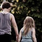 Due fratelli discutono di successione ereditaria con documenti e calcolatrice, rappresentando le nuove soglie fiscali.